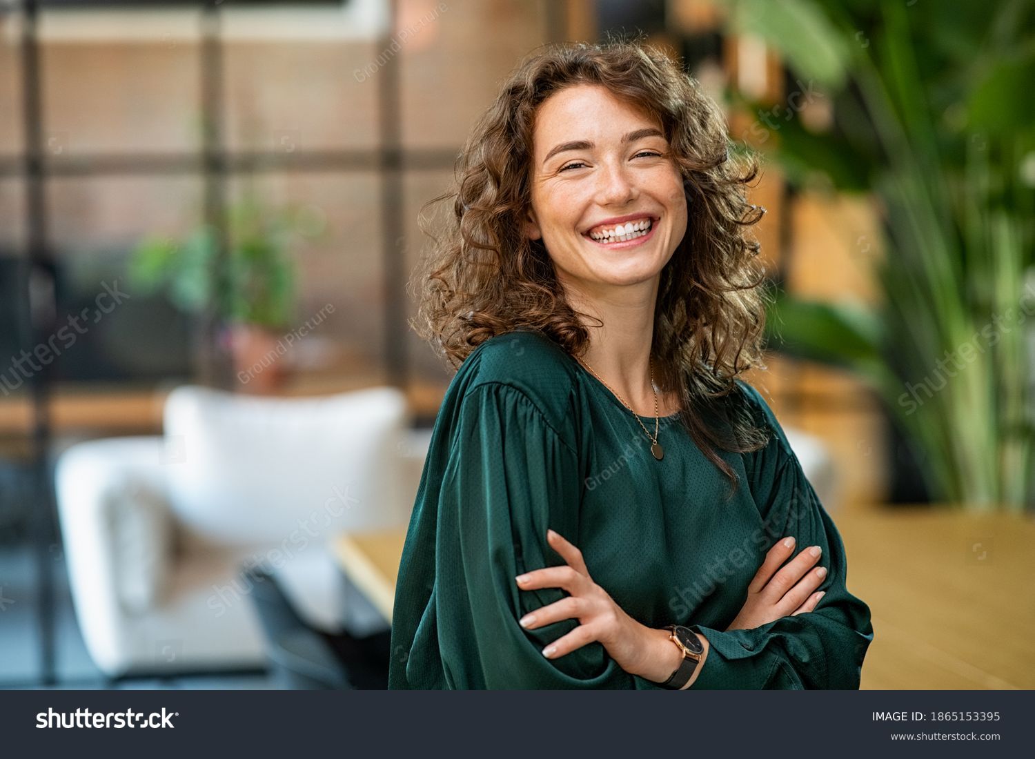 Stock-photo-portrait-of-young-smiling-woman-looking-at-camera-with-crossed-arms-happy-girl-standing-in-1865153395.jpg