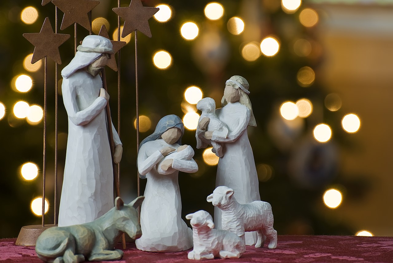 A depiction of the Nativity of Jesus with a Christmas tree backdrop
